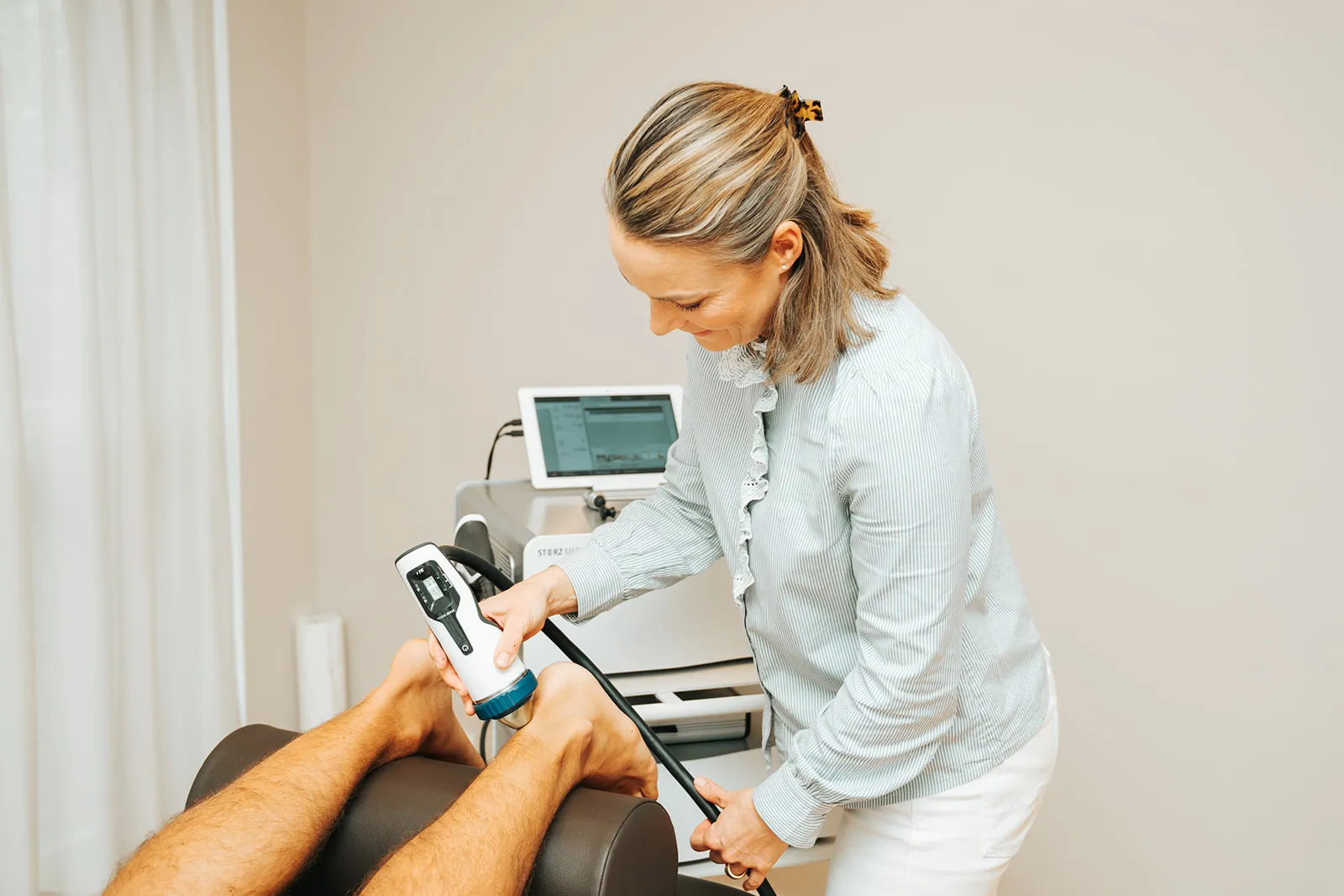Dr. Christin Buchholz bei der Stoßwellentherapie am Fuß